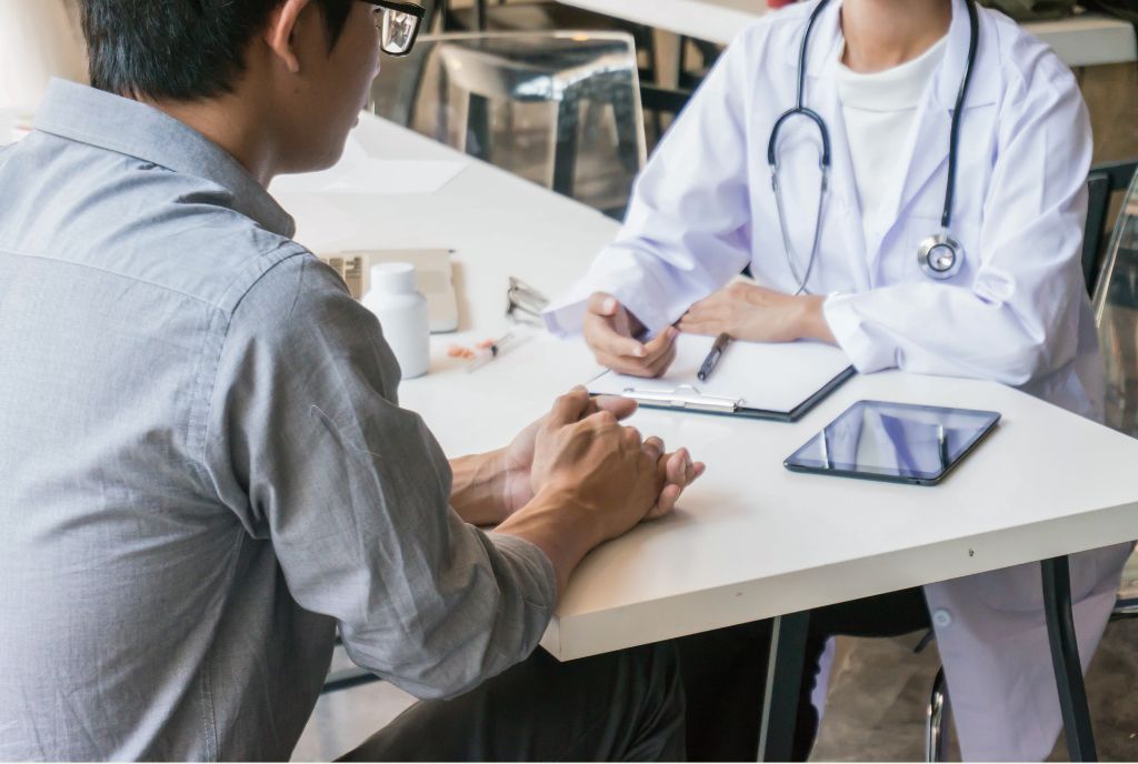 A doctor meeting with an man wearing glasses