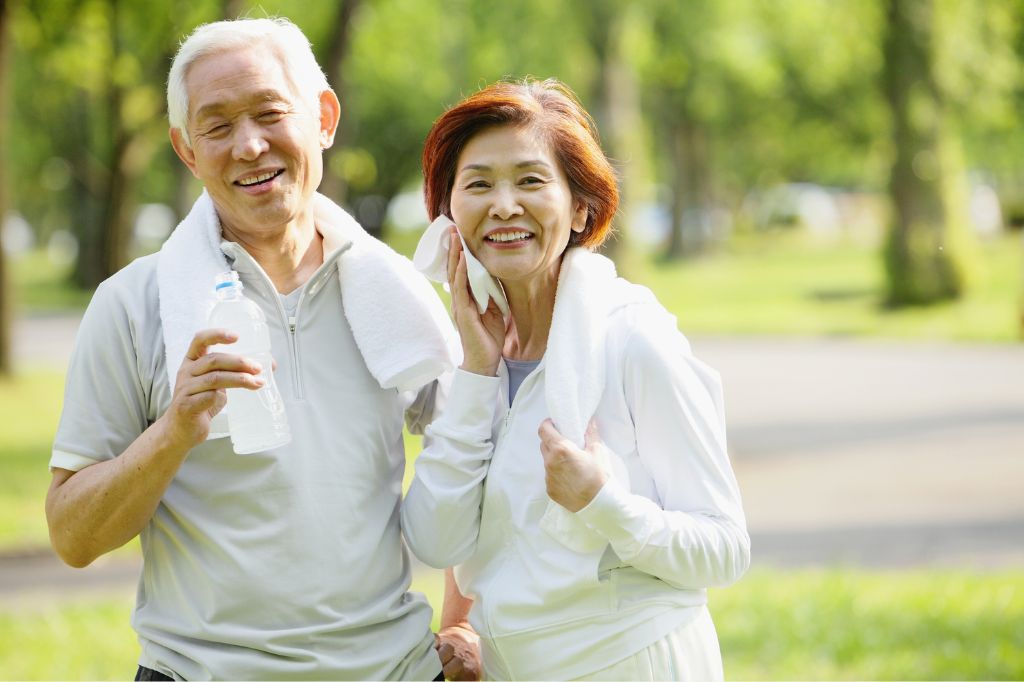 An elderly Asian couple with towels around their necks.