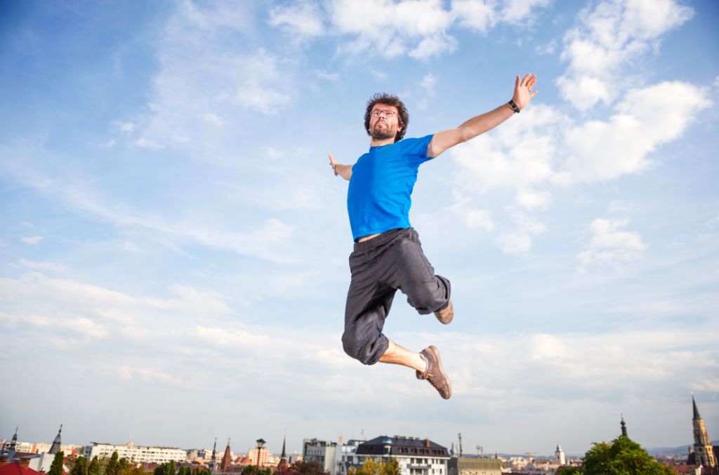 A man jumping in the sky with the city skyline below him