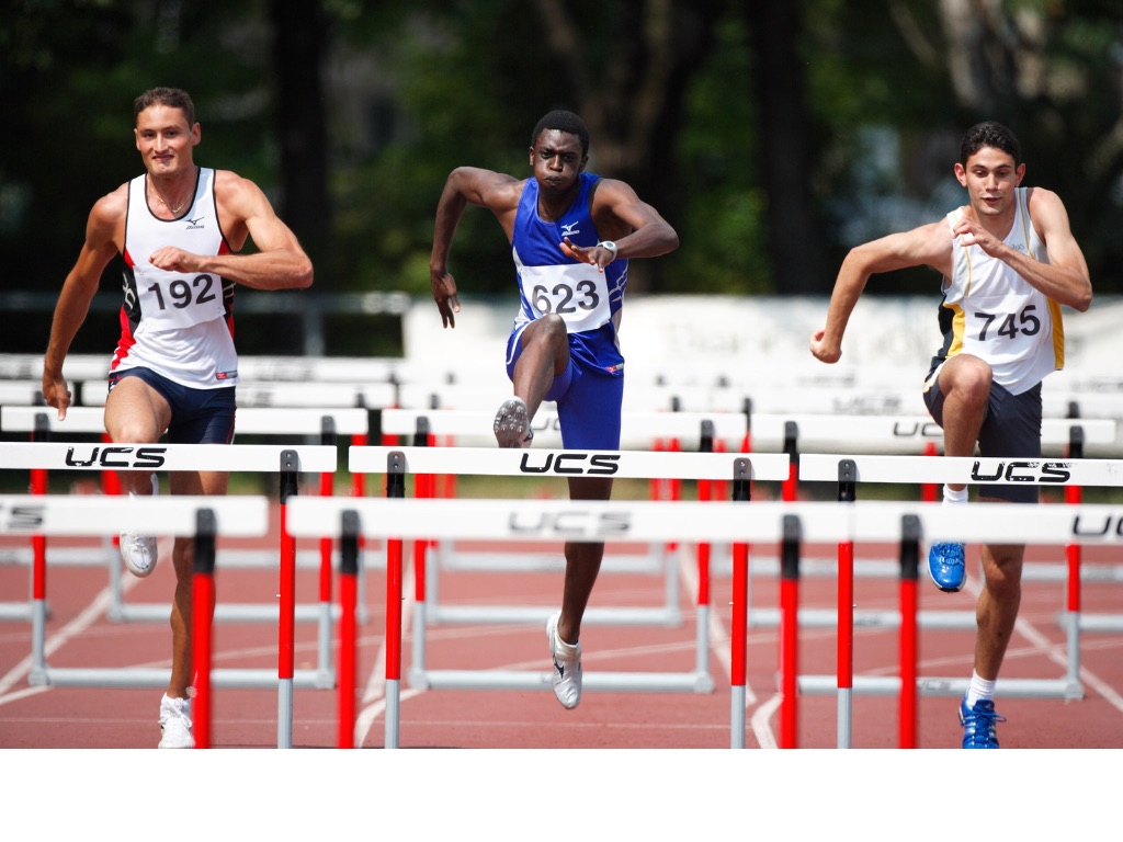 Sprinters running hurdles